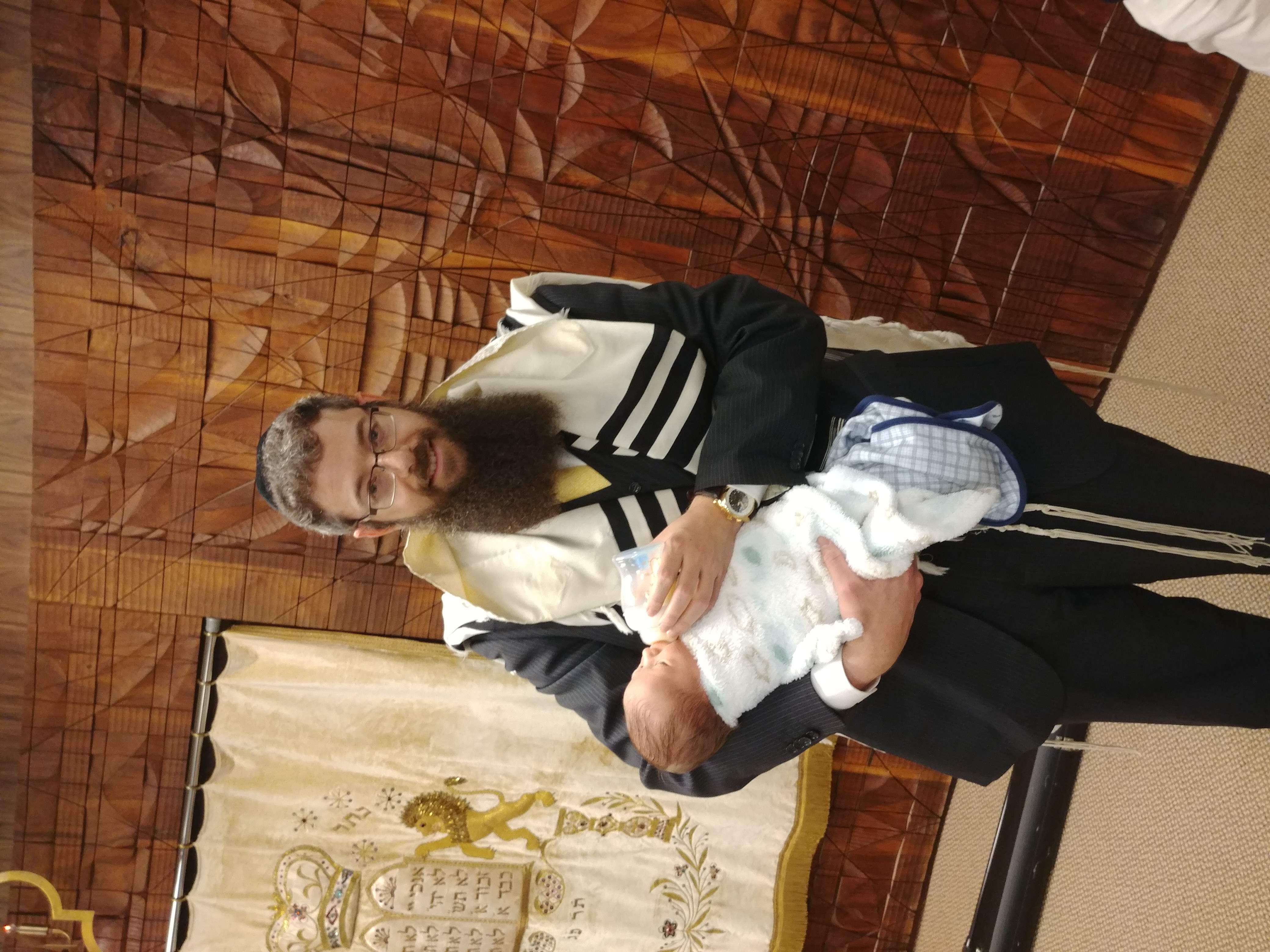 Rav Eliyahu Weisman holding a baby