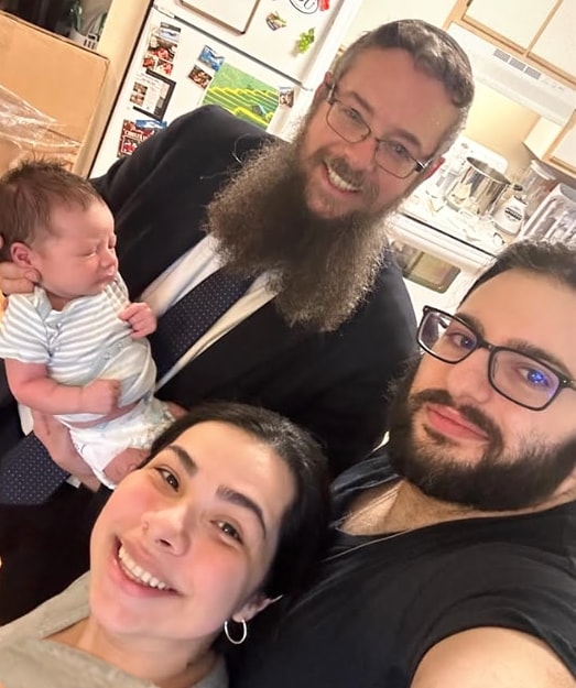 Rav Weisman with a newborn and his parents