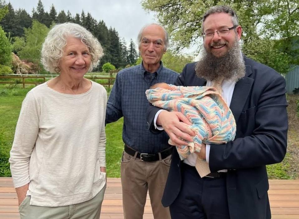 Rav Weisman with grandparents holding a newborn