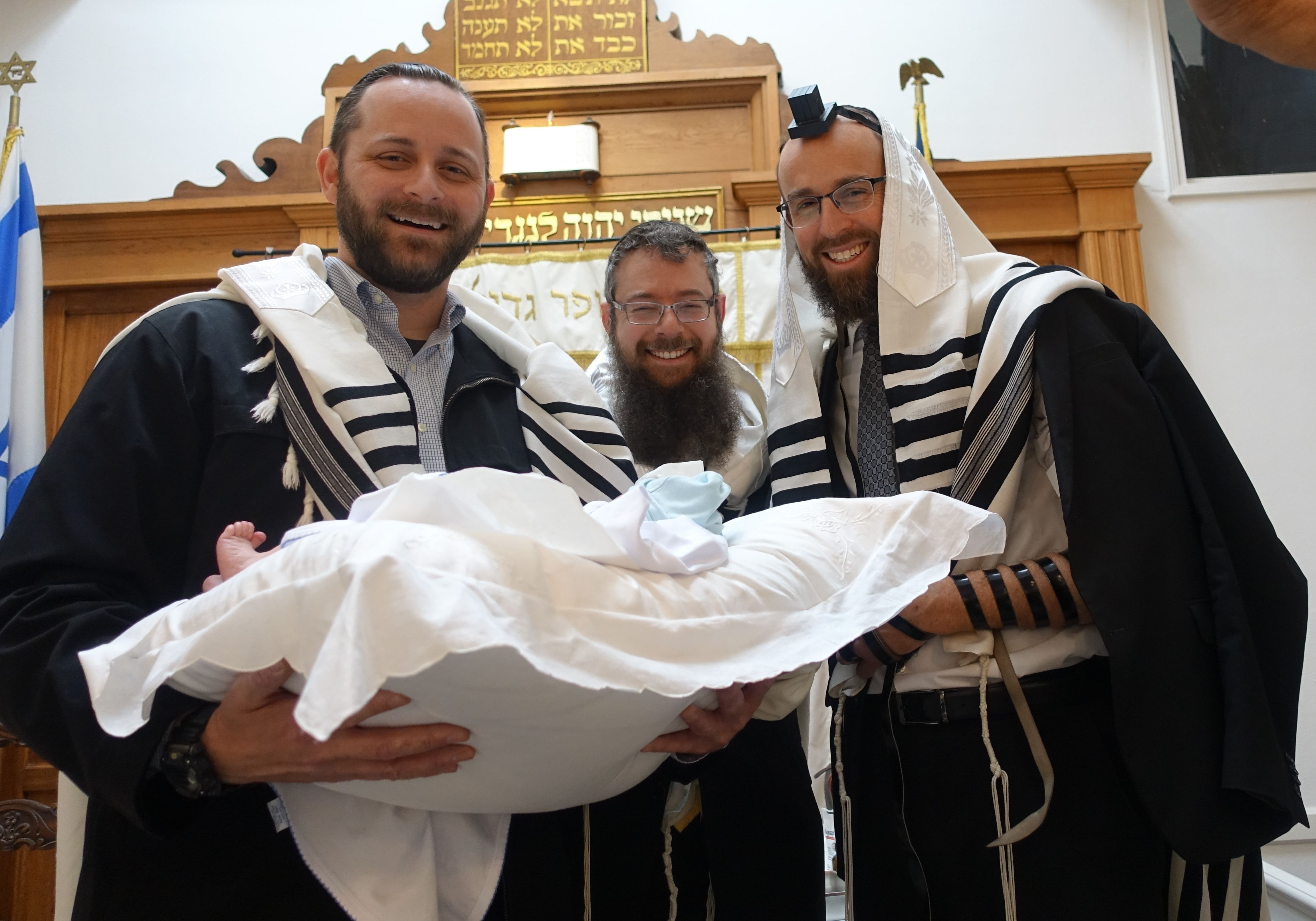 Rav Weisman with fellow Mohelim carrying a baby on a bris pillow